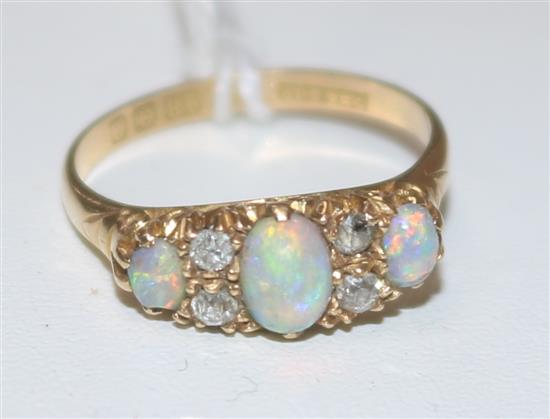 An early 20th century 18ct gold white opal and diamond half hoop cluster ring, size 0.